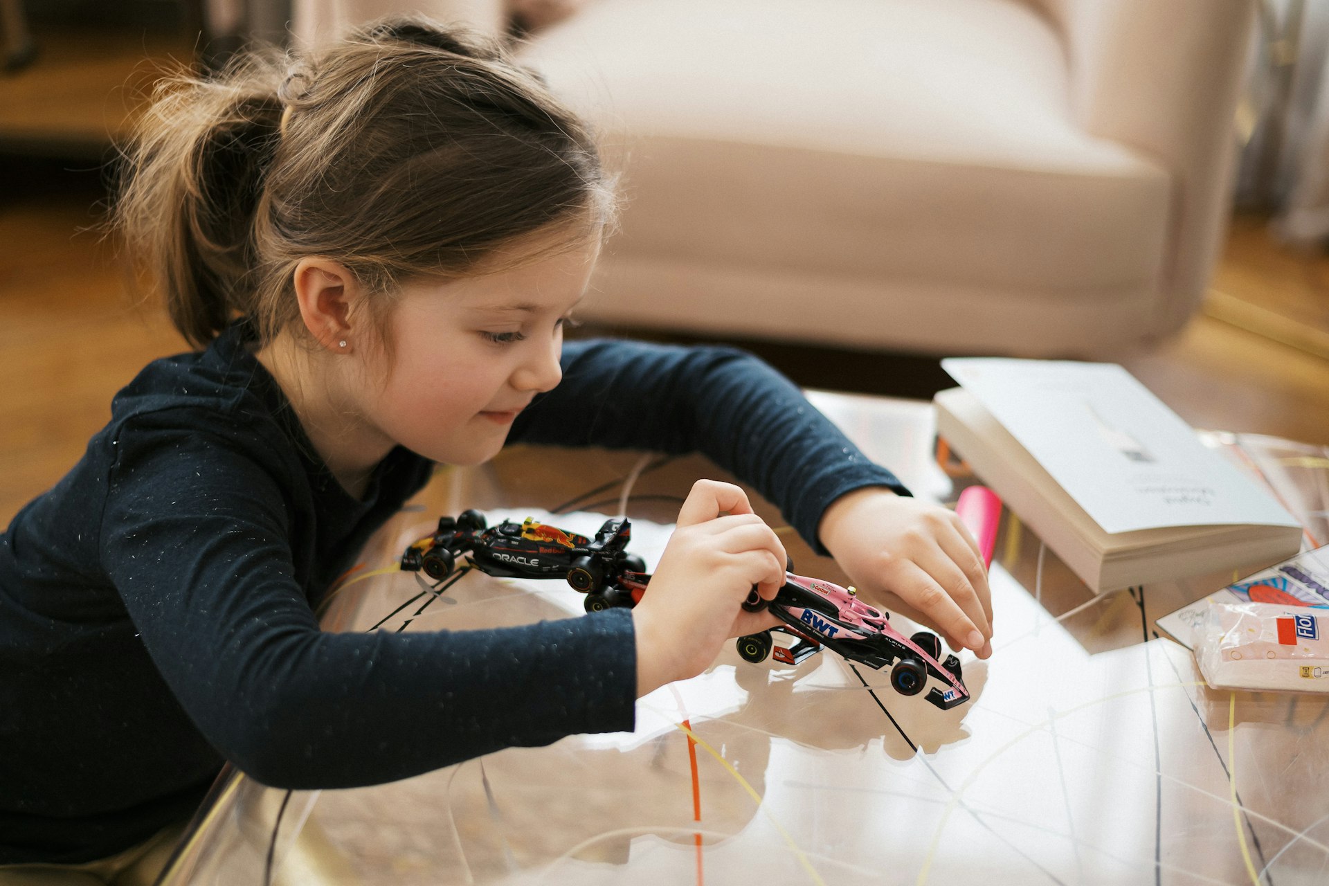 Girl is building a toy car with concentration
